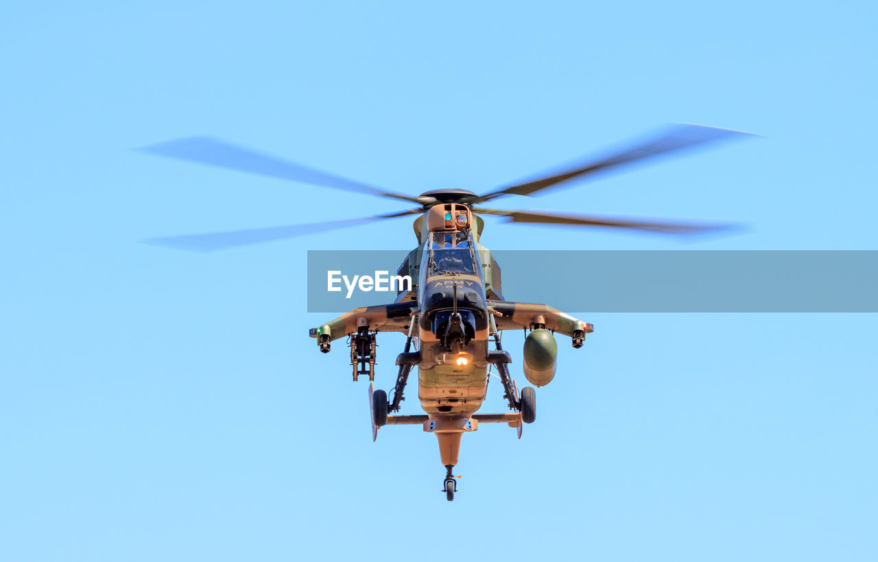 LOW ANGLE VIEW OF HELICOPTER FLYING IN SKY