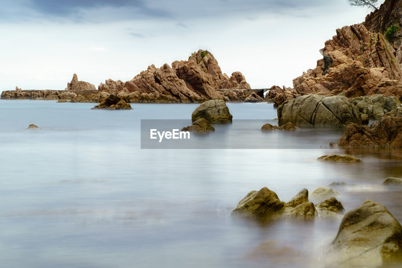 ROCK FORMATIONS IN SEA AGAINST SKY