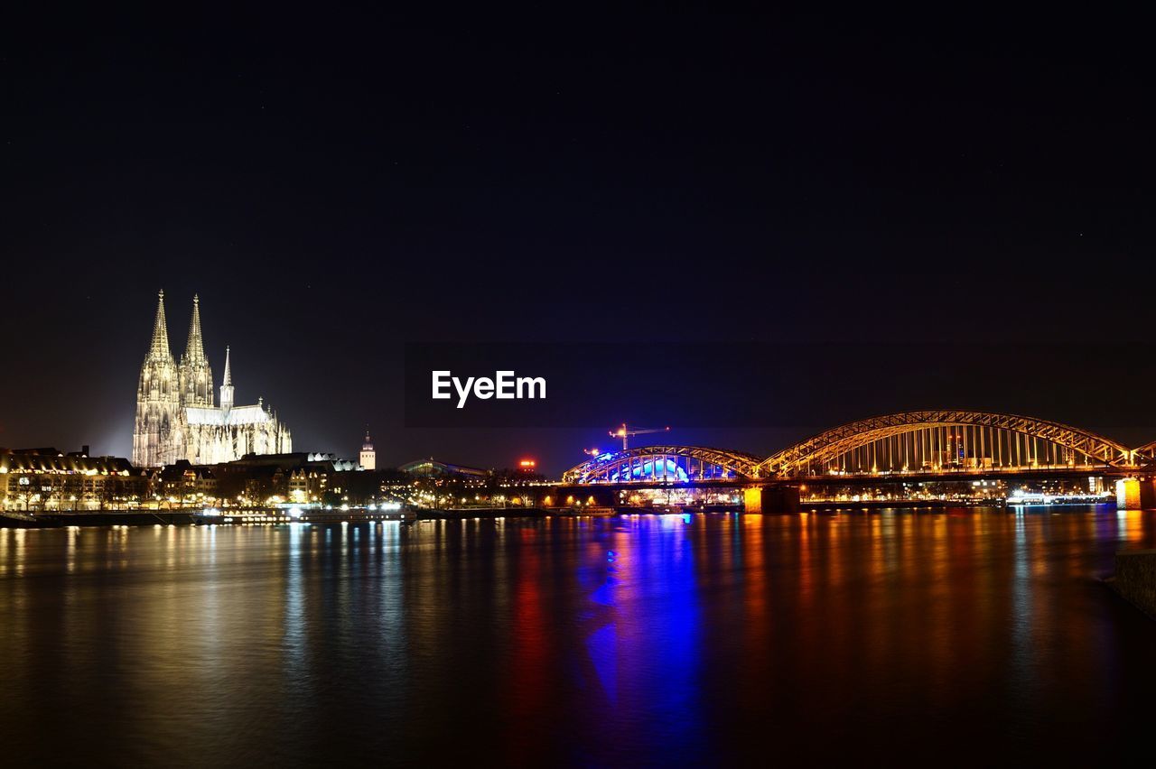 Illuminated city with rhine river against clear sky