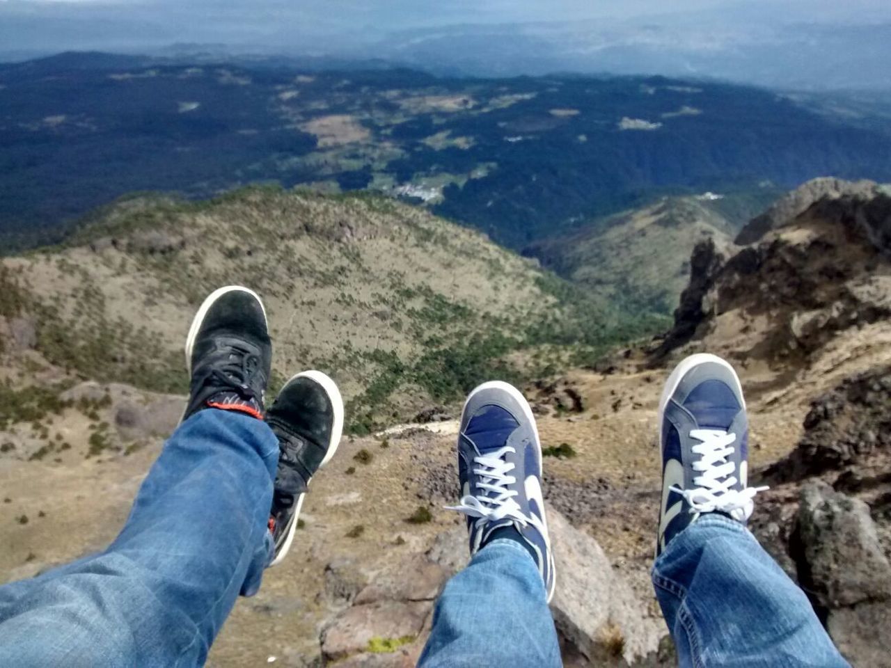 Low section of friends relaxing on mountain