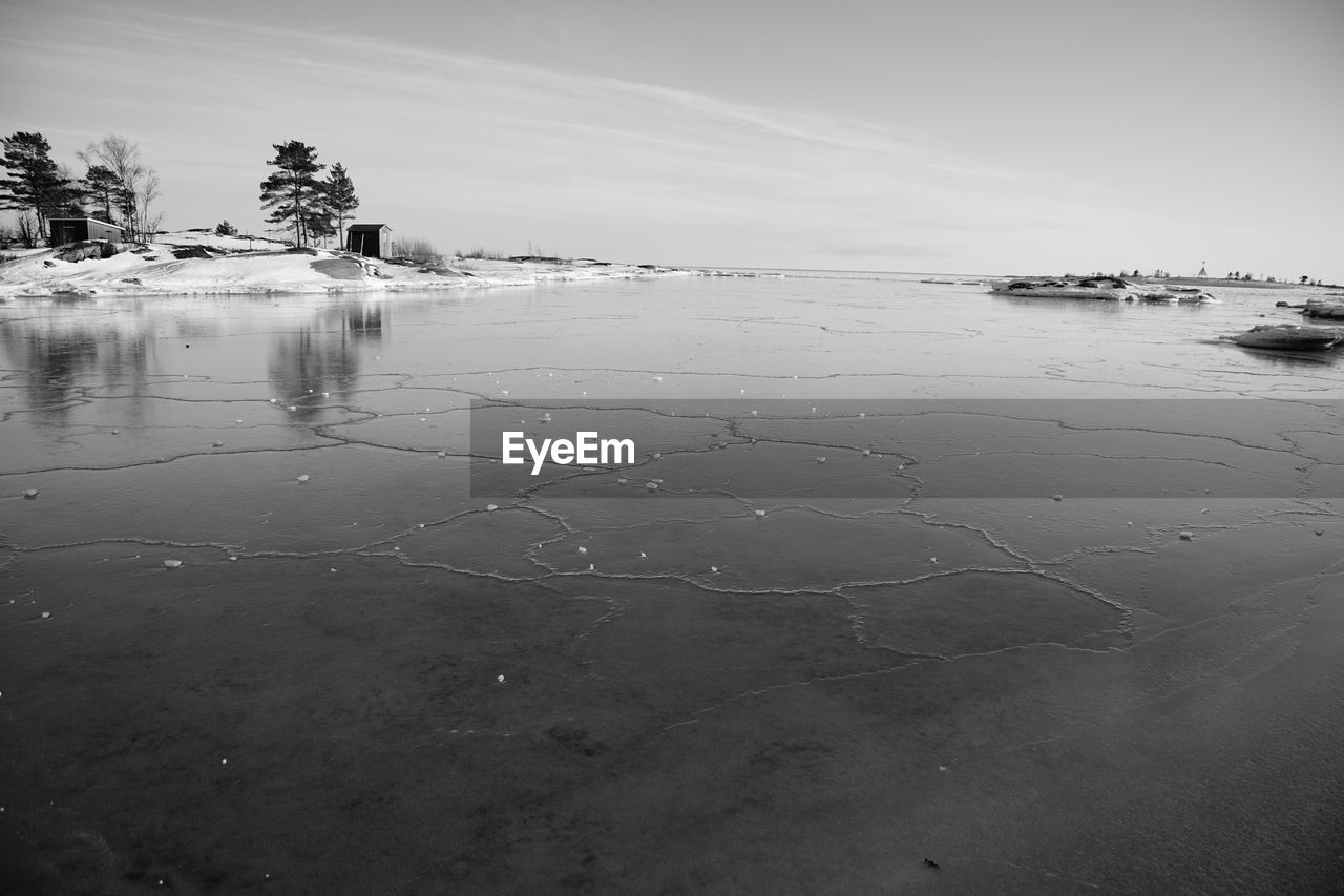 water, sky, reflection, land, nature, scenics - nature, black and white, sea, tranquility, monochrome, beauty in nature, beach, horizon, monochrome photography, environment, tree, tranquil scene, cloud, landscape, white, morning, wave, no people, day, plant, outdoors, shore, ocean, sand, non-urban scene, coast, snow, travel destinations, sunlight, idyllic, travel