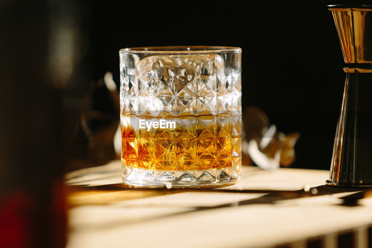 Close-up of glass with bourbon whiskey on table