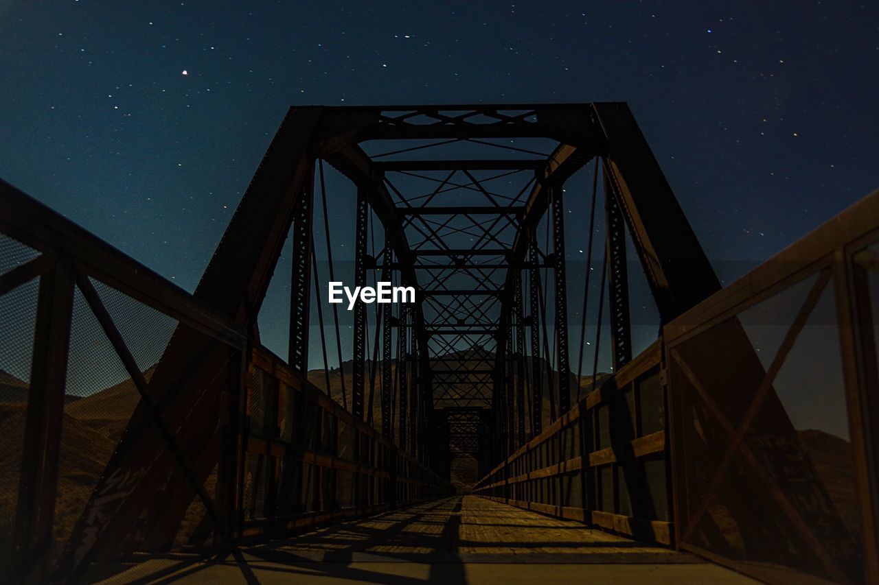 Low angle view of bridge against sky at night