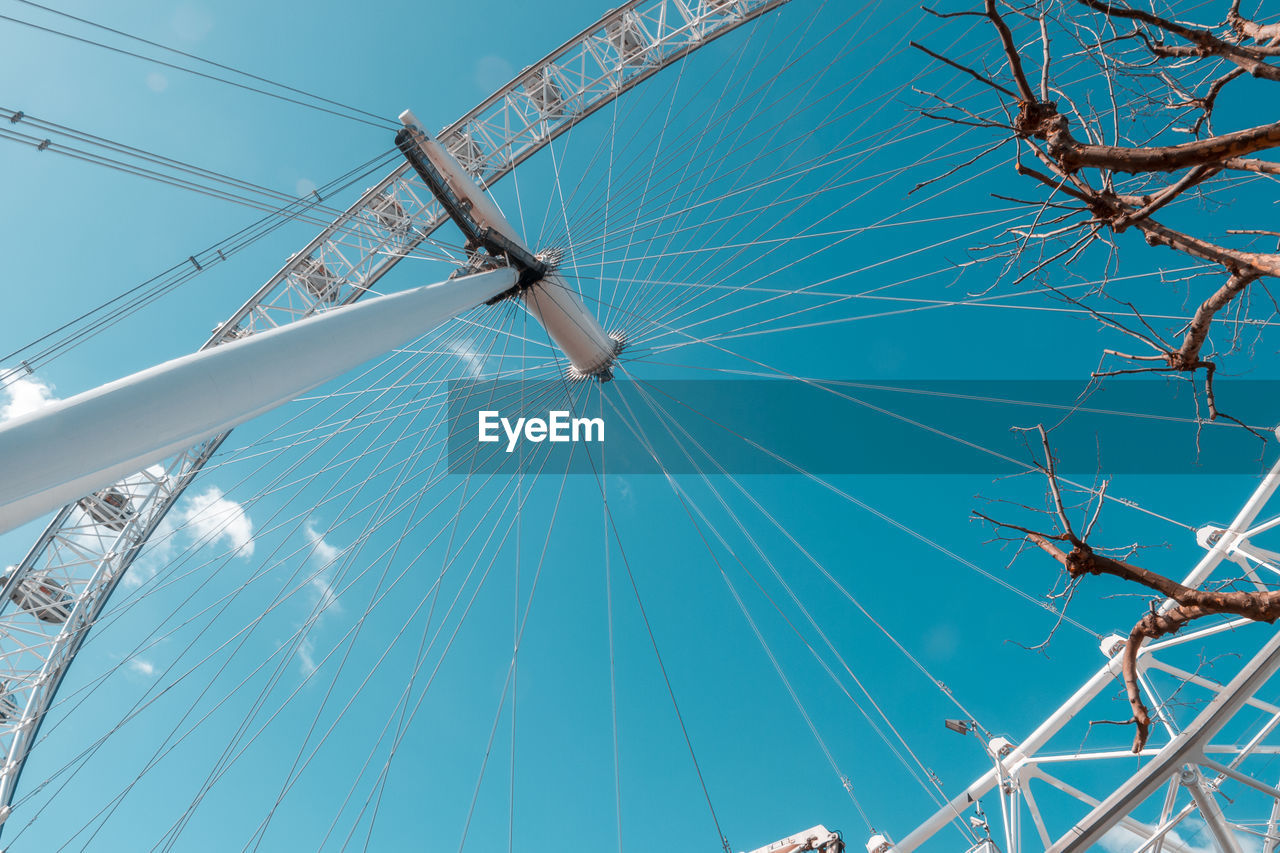 Low angle view of millennium wheel against blue sky in city