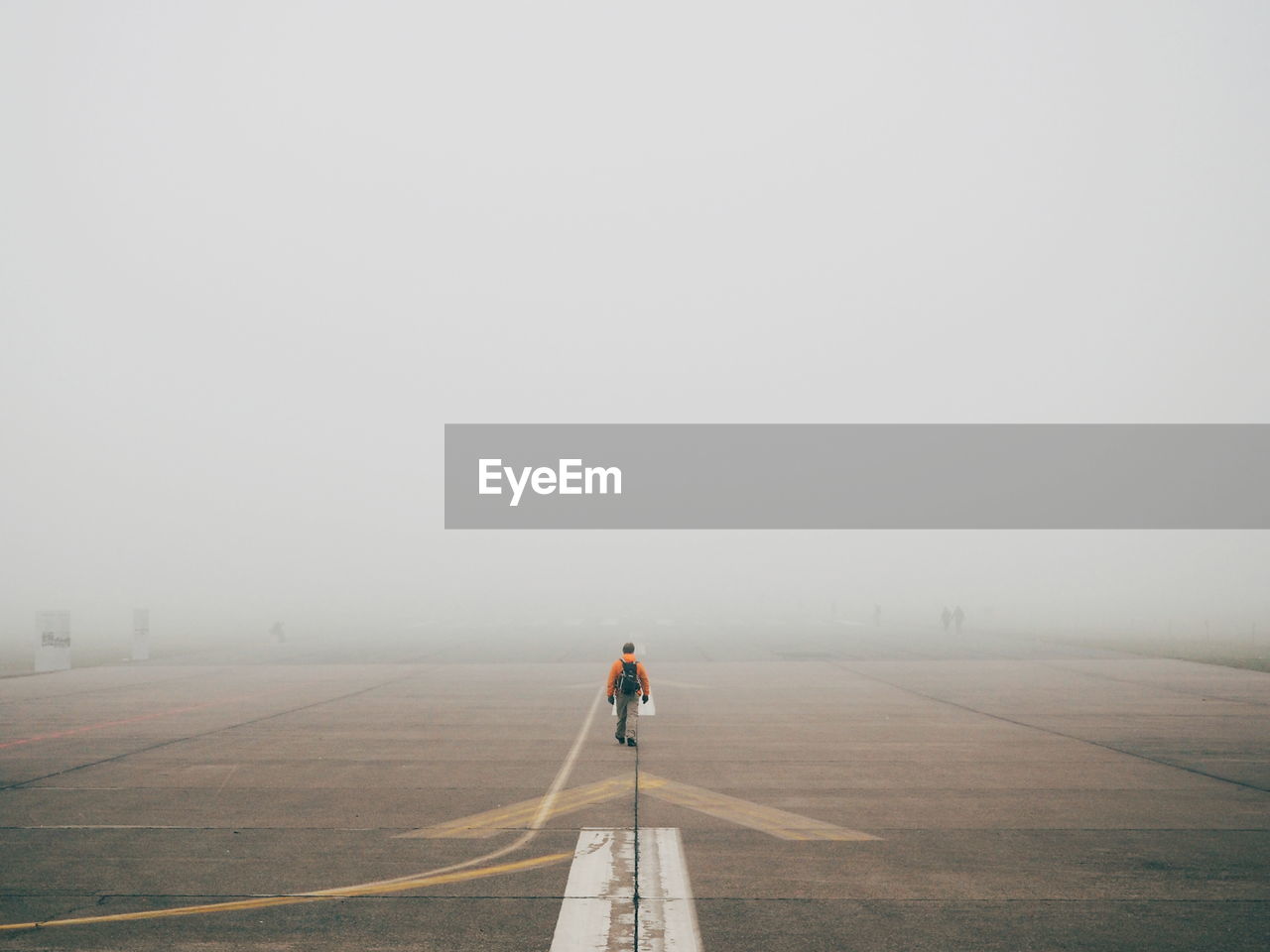 Man walking on tempelhofer feld in fog