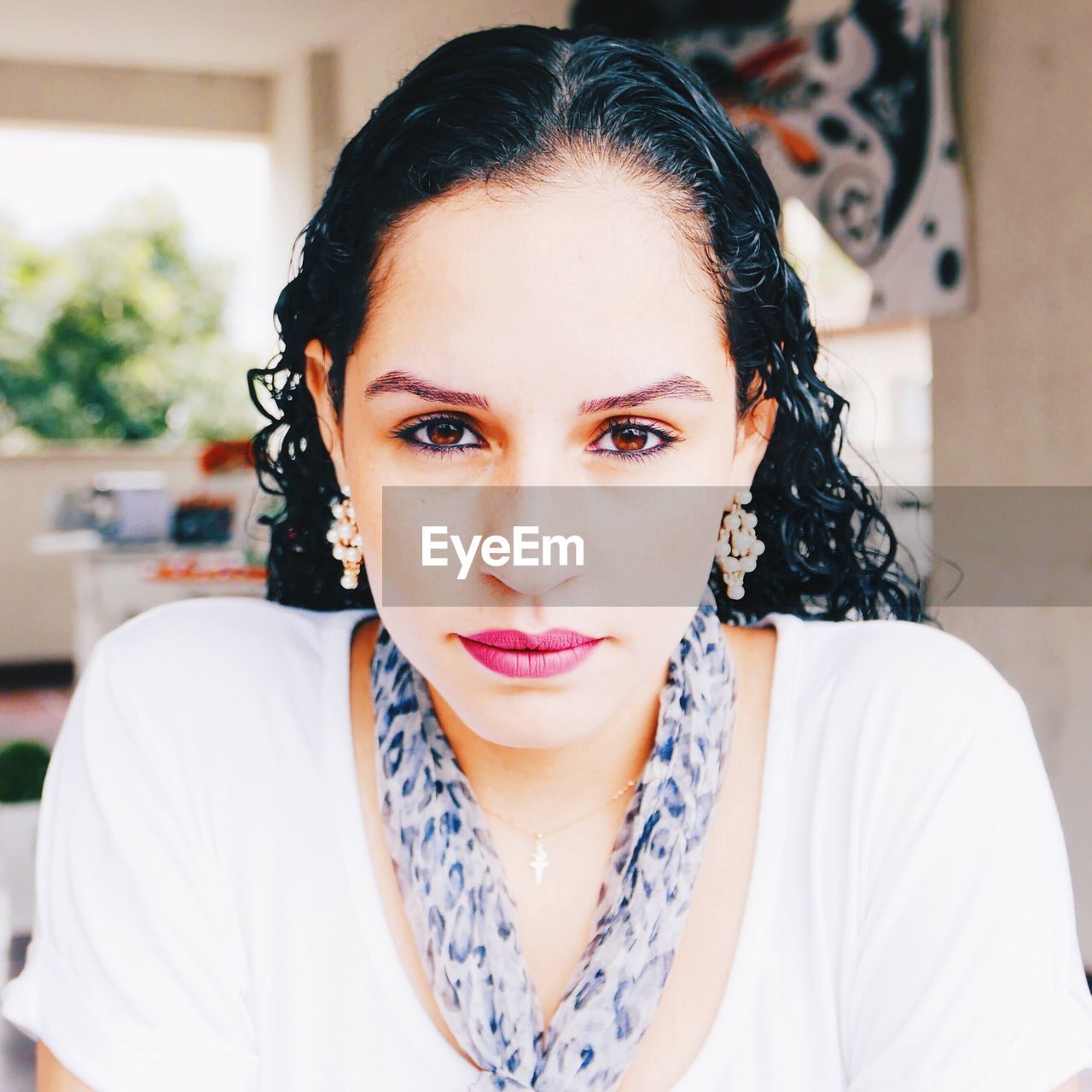 Portrait of young woman wearing make-up at home