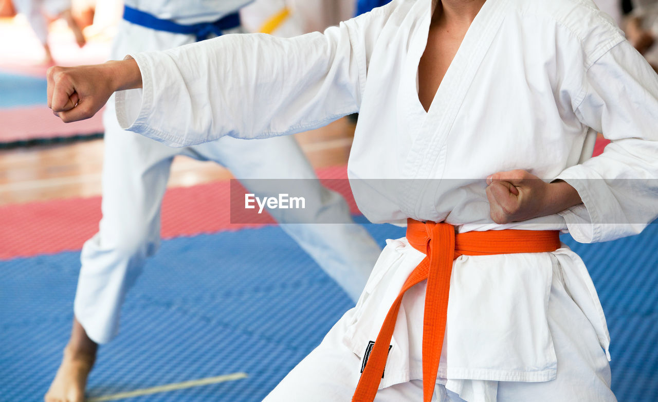 Midsection of women practicing karate