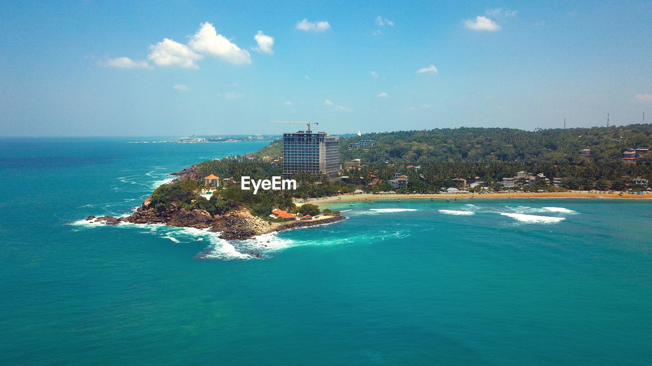 SCENIC VIEW OF SEA AGAINST BUILDINGS IN CITY