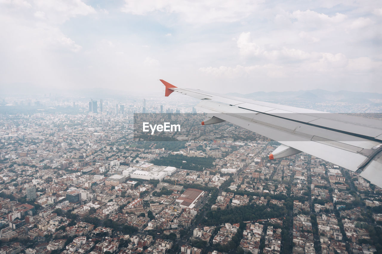 Cropped image of airplane flying over cityscape 