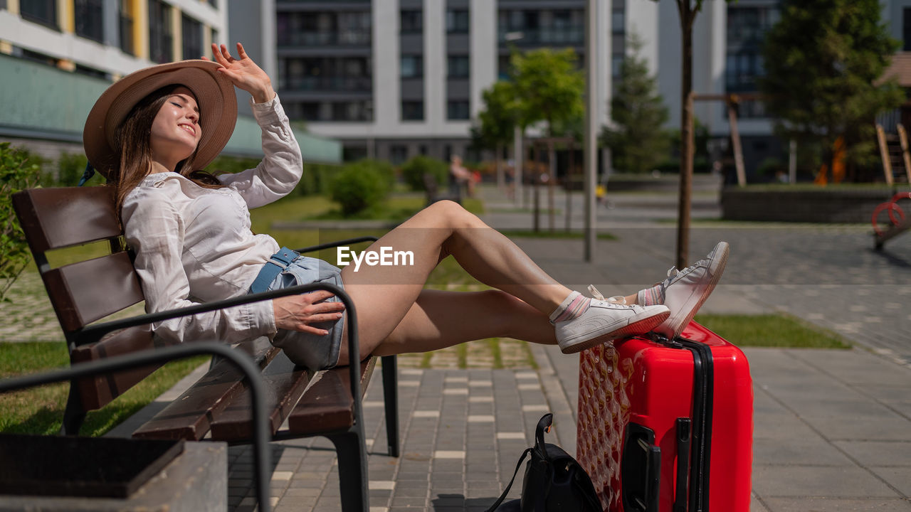 FULL LENGTH OF WOMAN SITTING IN PARK