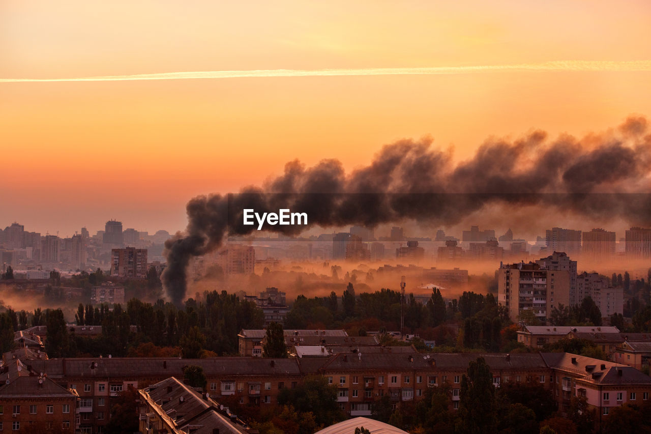 Early morning cityscape with black smoke from the conflagration.