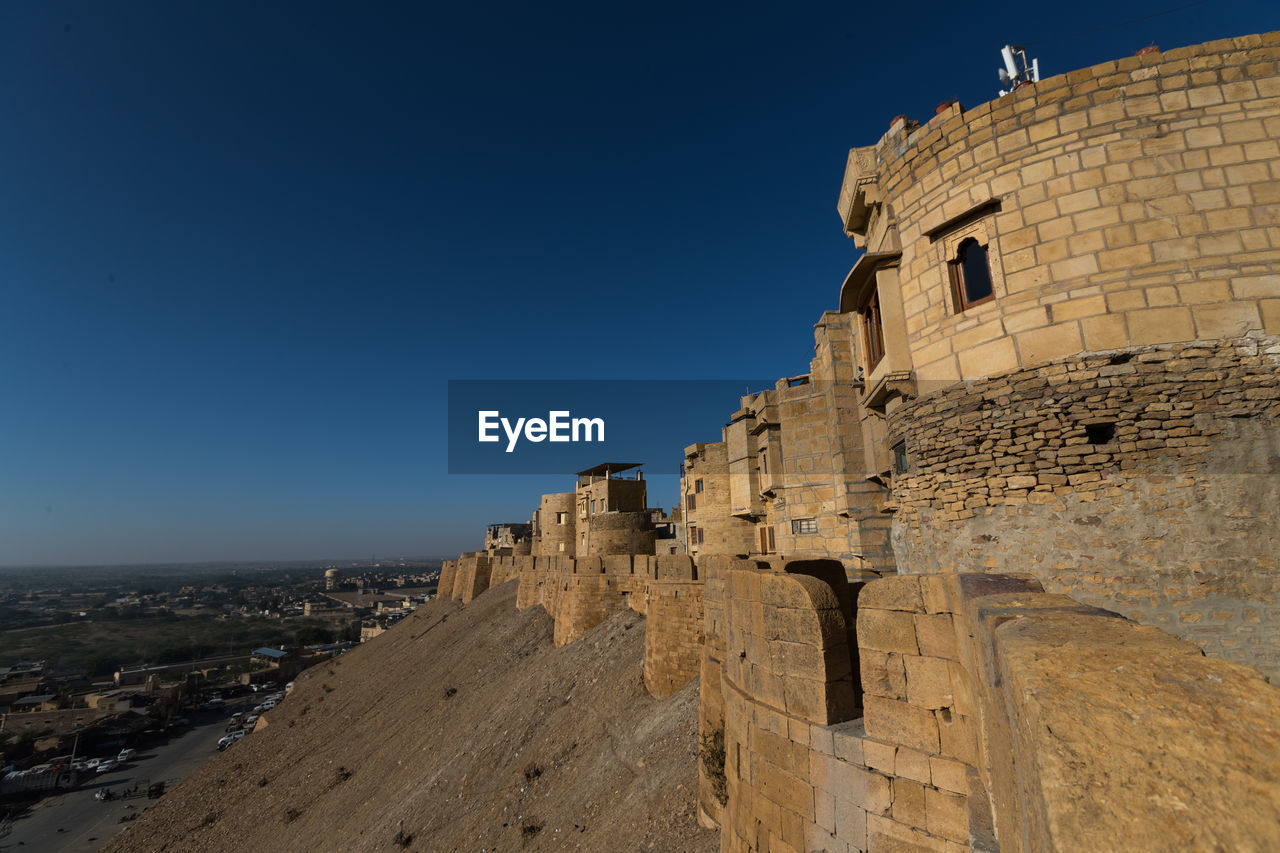 Ruins of building against clear blue sky