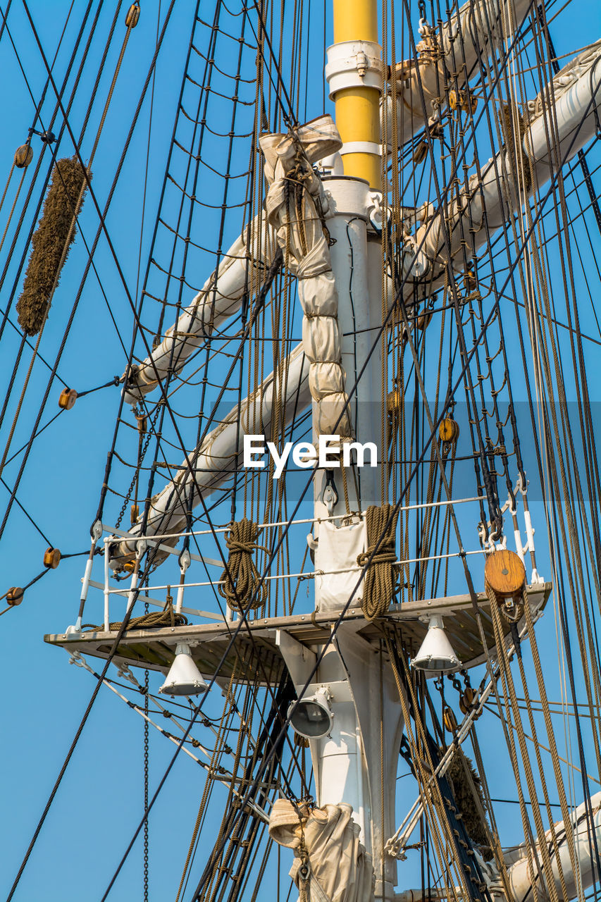 Low angle view of ship mast against clear blue sky