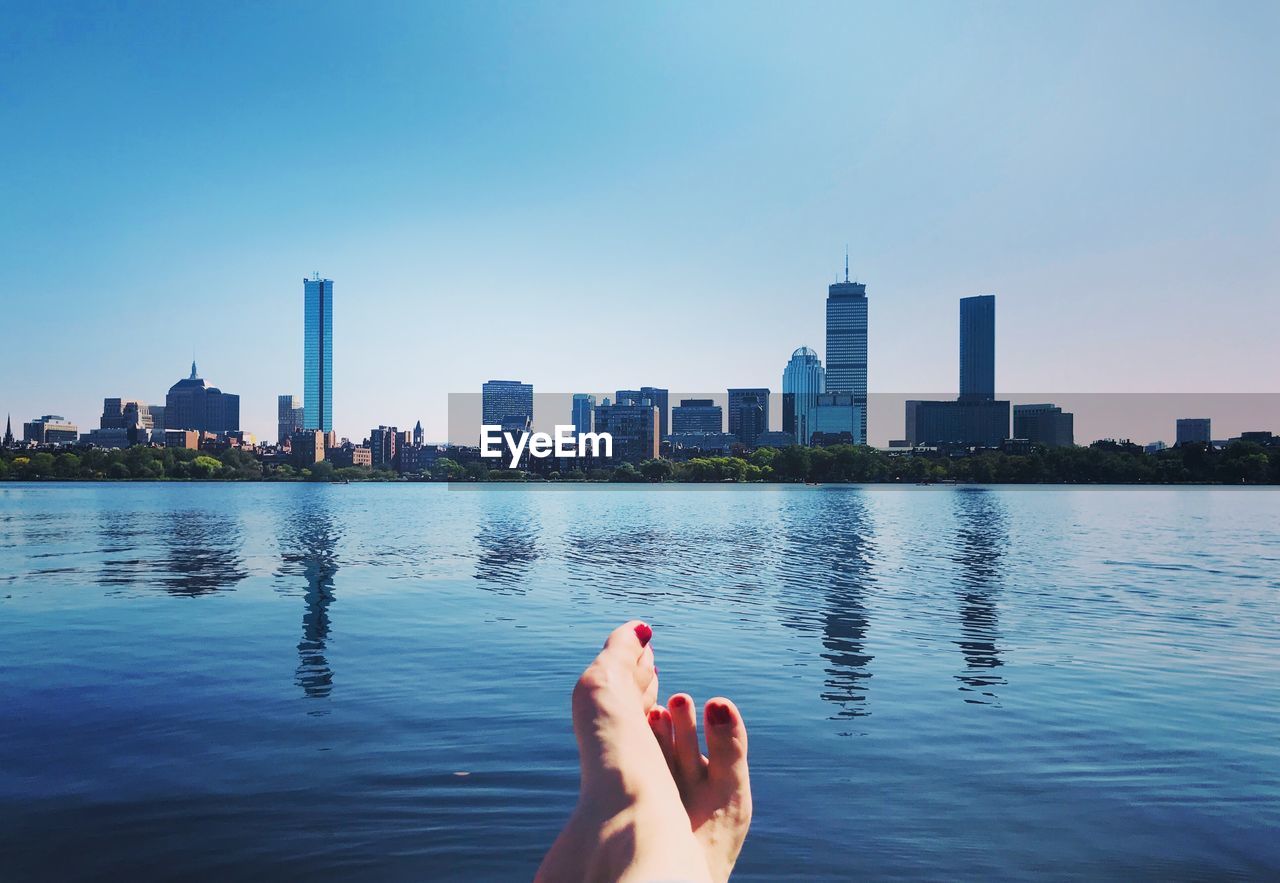 Barefoot by charles river against buildings in boston