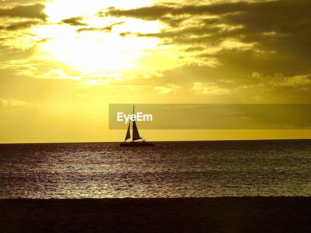 SILHOUETTE SAILBOAT IN SEA AGAINST SUNSET SKY