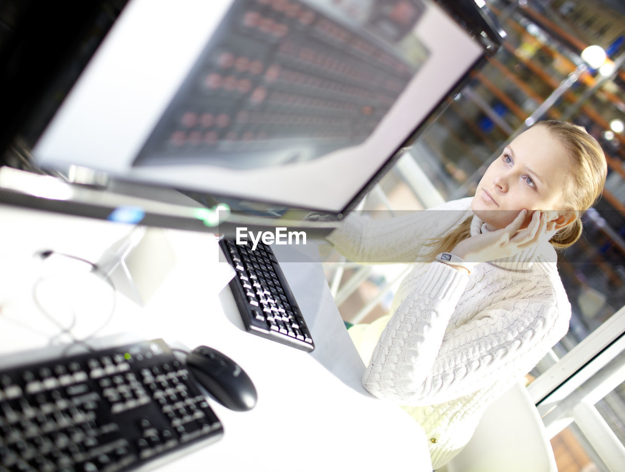 Woman using computer at desk in office