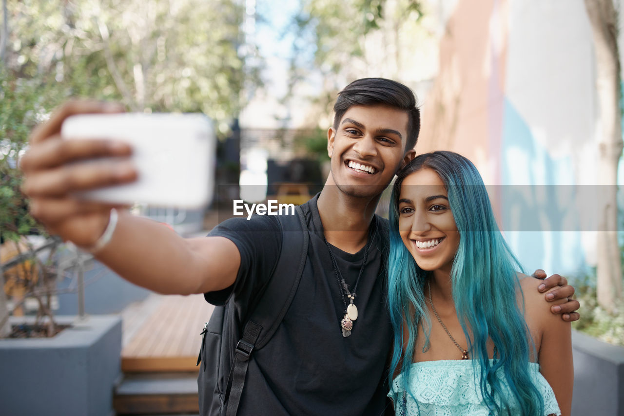 Portrait of smiling friends taking selfie