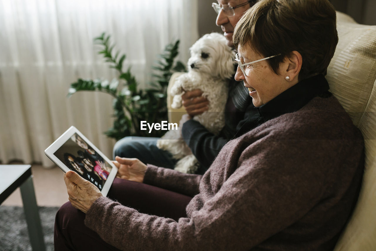 Grandparents on video call with family through tablet at home