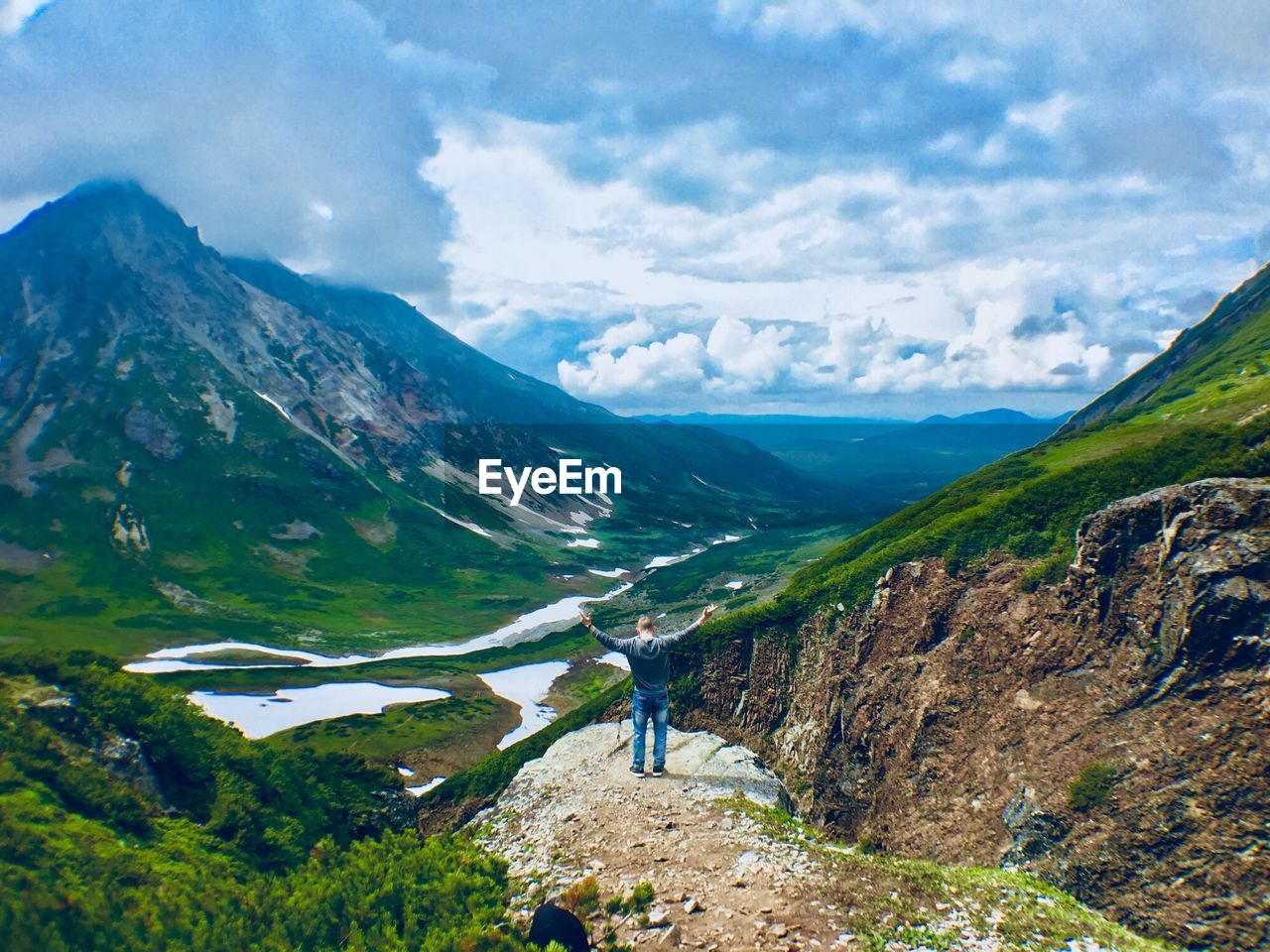 High angle view of man standing on cliff against mountains