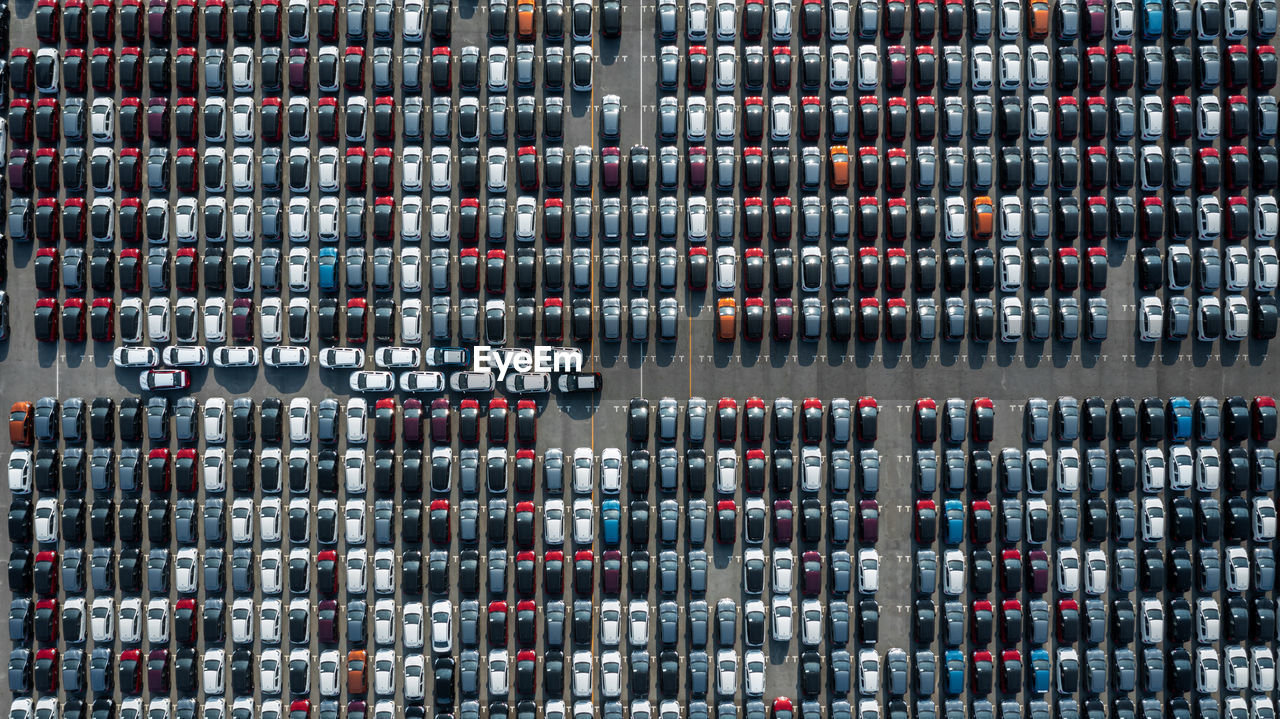 Aerial top view rows of new cars parked in distribution center on car factory.