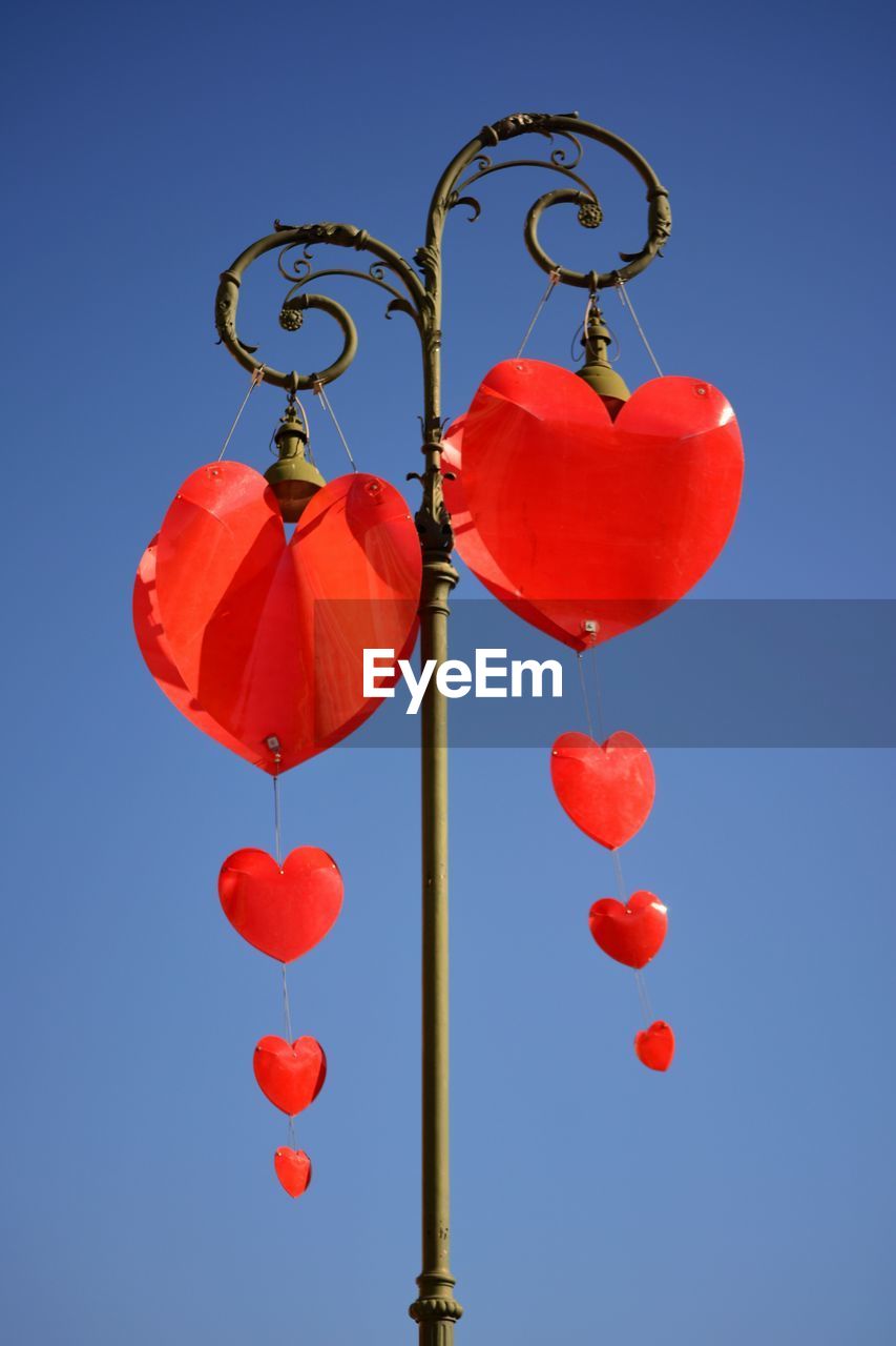 Low angle view of hanging light against clear blue sky