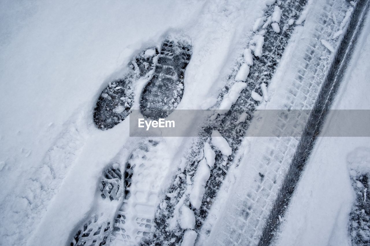 High angle view of tire tracks on snow covered land