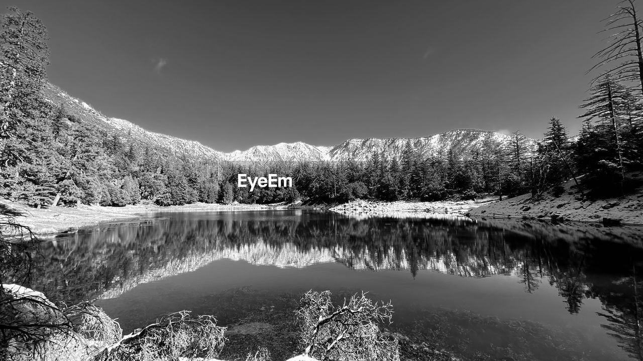 water, tree, lake, reflection, scenics - nature, nature, beauty in nature, black and white, tranquility, plant, snow, tranquil scene, winter, monochrome, sky, monochrome photography, forest, mountain, environment, coniferous tree, pinaceae, no people, pine tree, landscape, cold temperature, pine woodland, non-urban scene, land, woodland, wilderness, idyllic, outdoors, travel destinations, mountain range