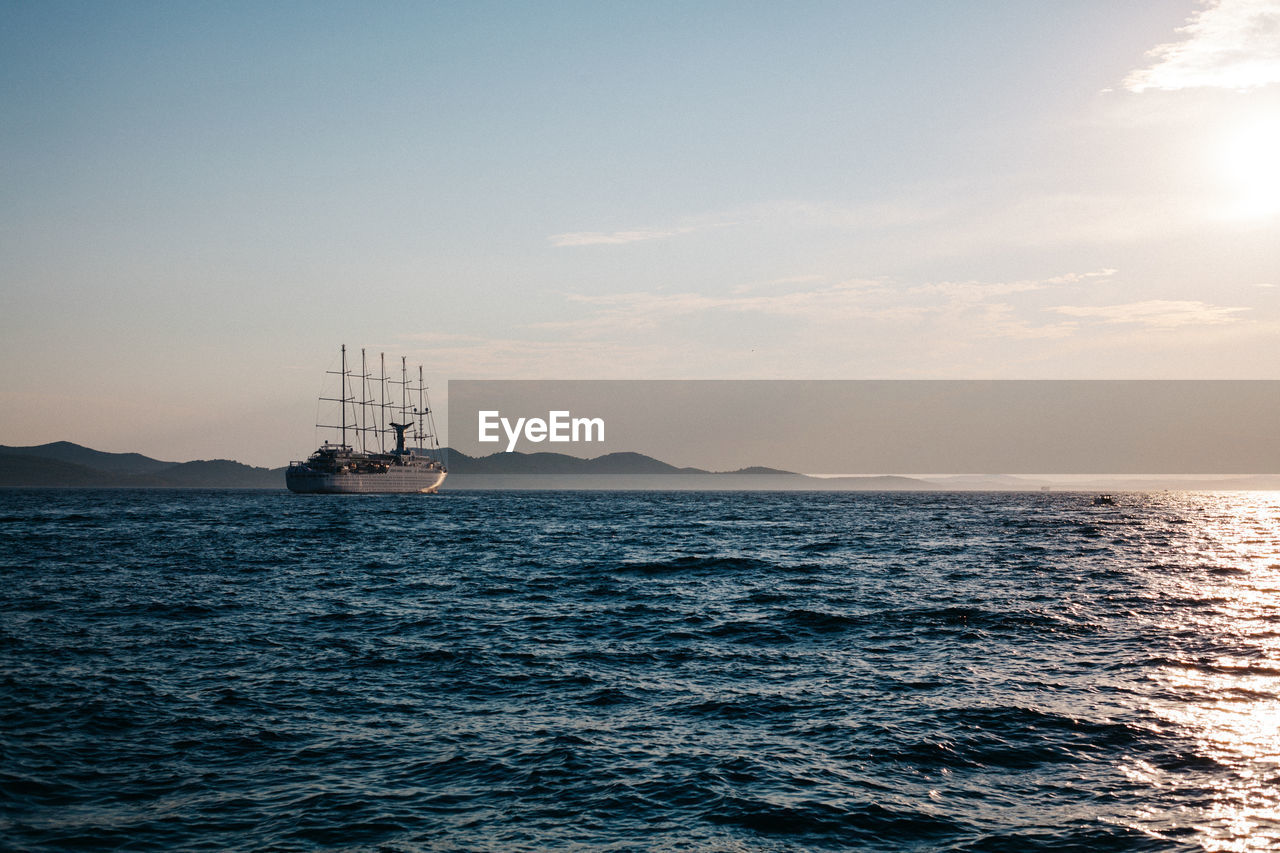 Sailboat sailing on sea against sky