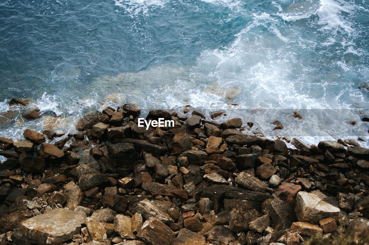 HIGH ANGLE VIEW OF WAVES ON SHORE