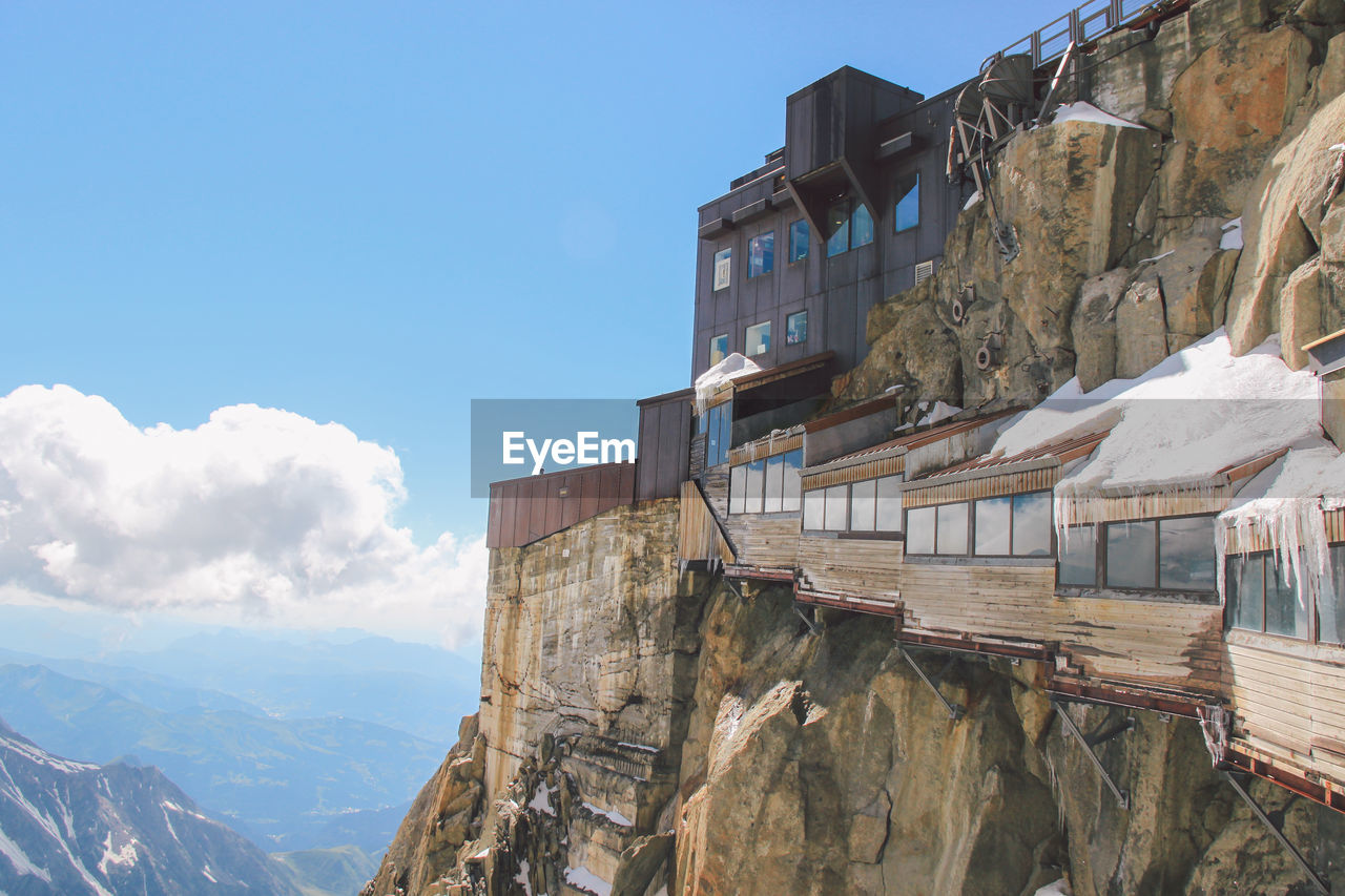 Buildings on rocky mountains at aiguille de midi