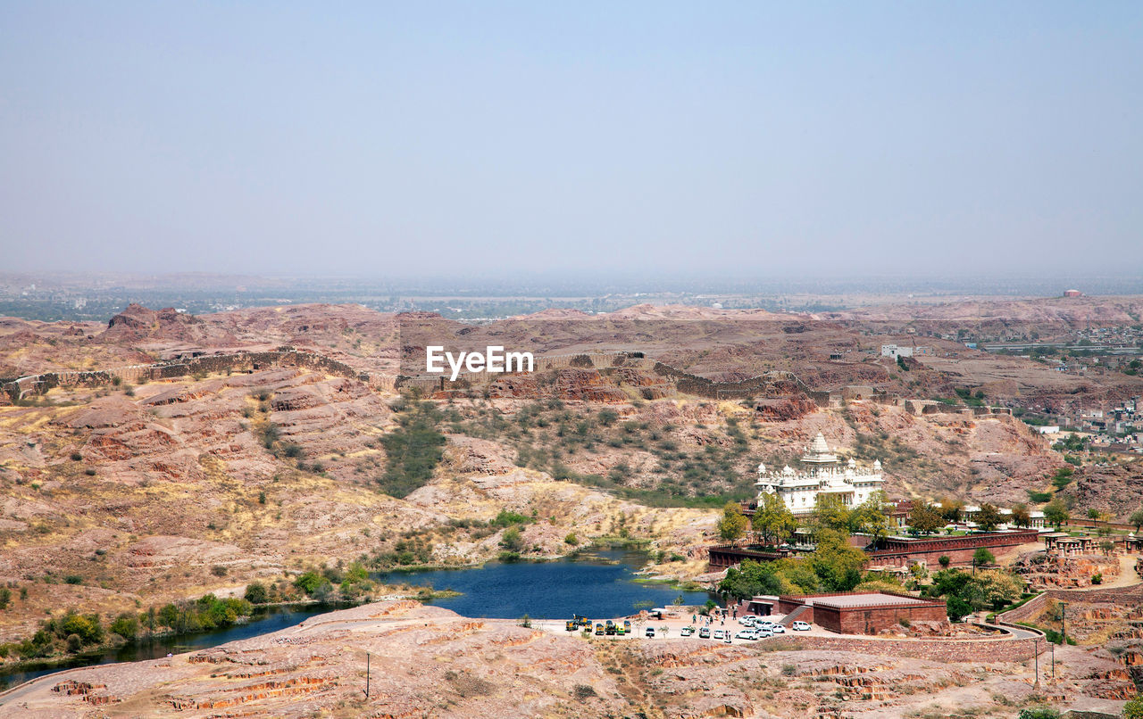 Jaswant thada by lake against clear sky on sunny day