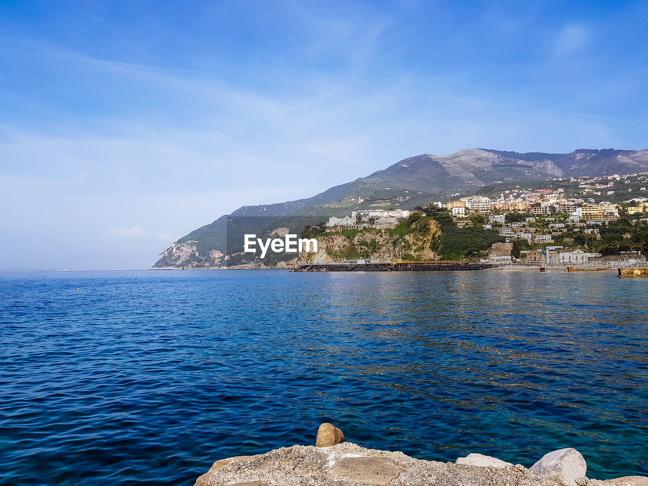 SCENIC VIEW OF SEA AND ROCKS AGAINST BLUE SKY