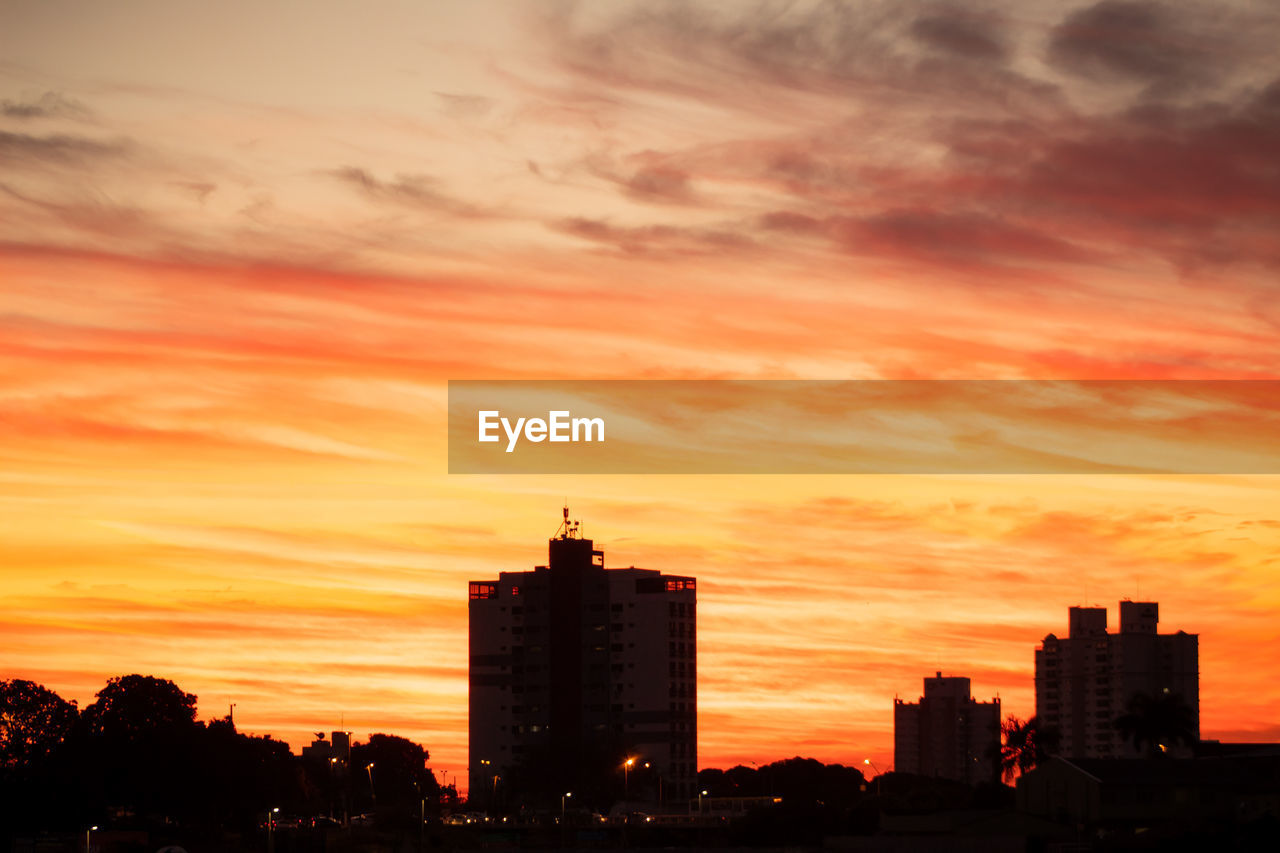 SILHOUETTE BUILDINGS AGAINST SKY AT SUNSET