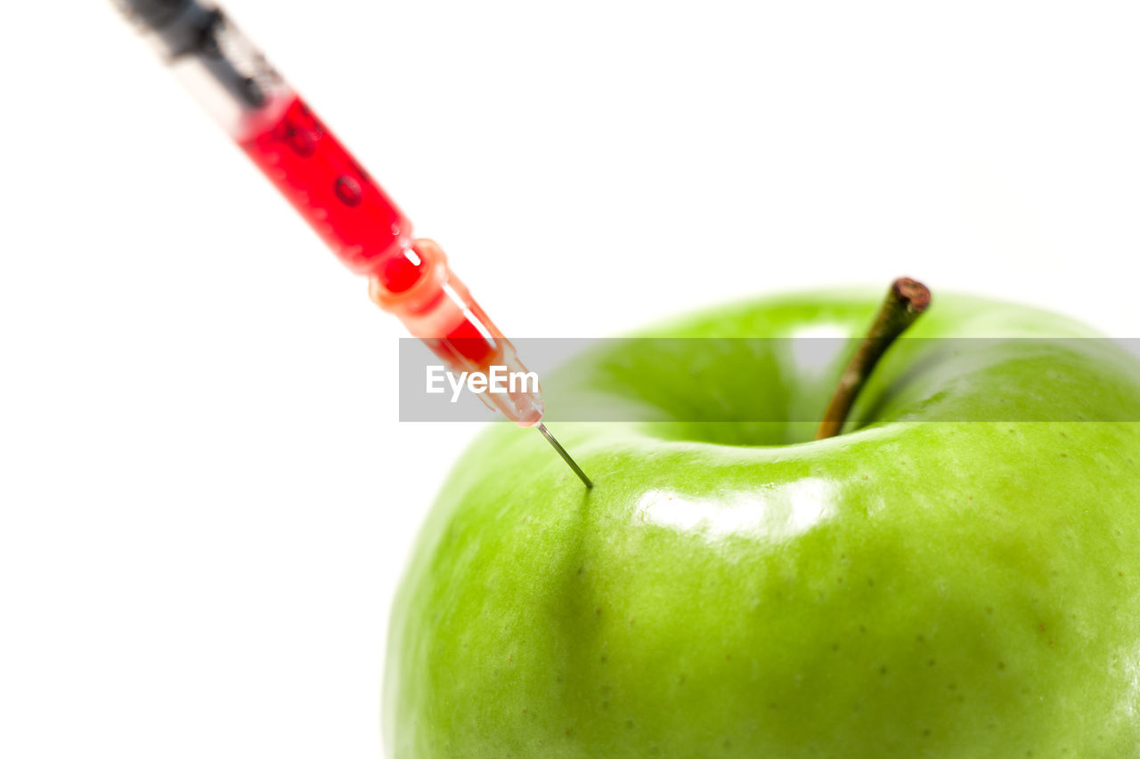 CLOSE-UP OF APPLE ON RED BACKGROUND