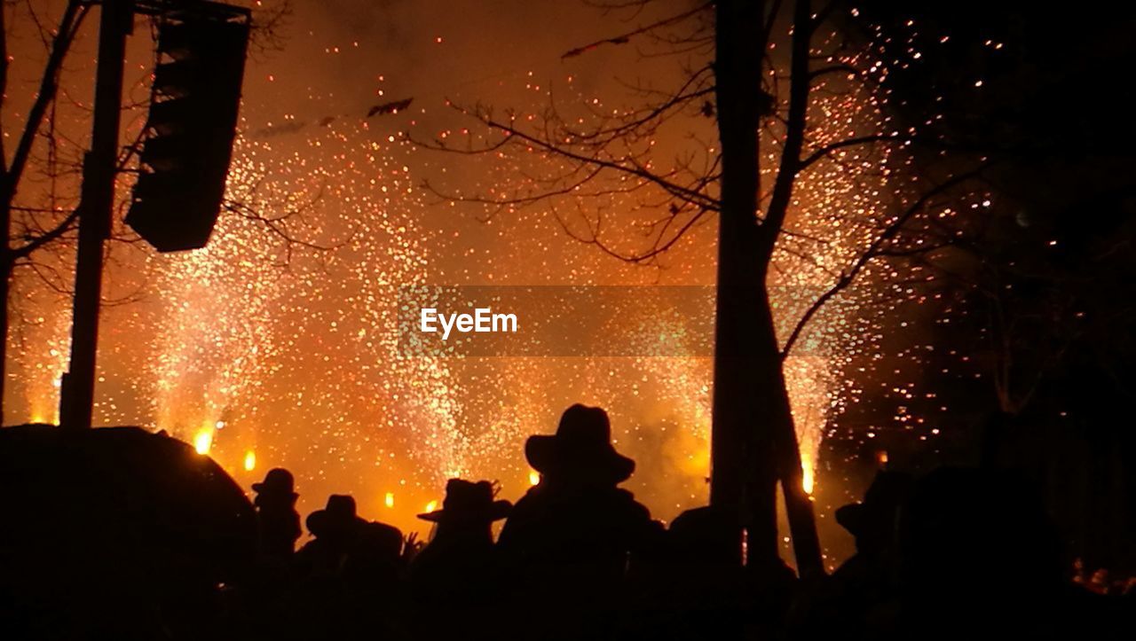 SILHOUETTE PEOPLE AGAINST SKY WITH FIRE CRACKERS