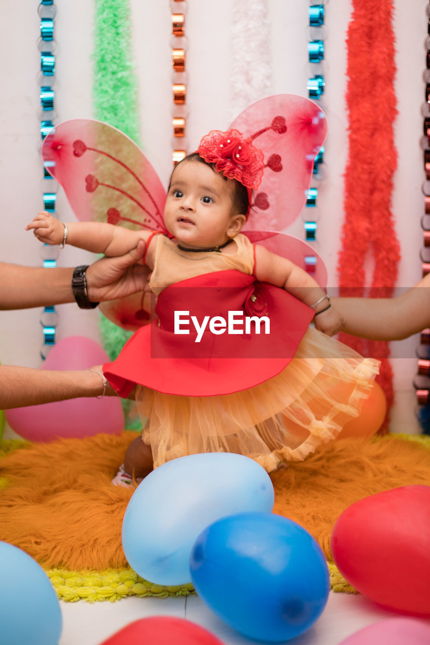 Parents holding baby girl during celebration at home