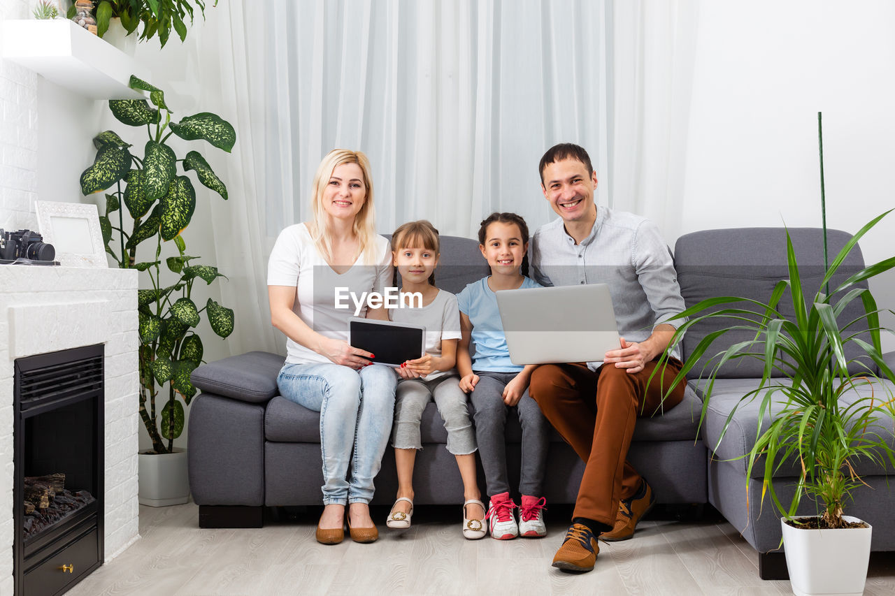 Young parents, with children, on laptop computer