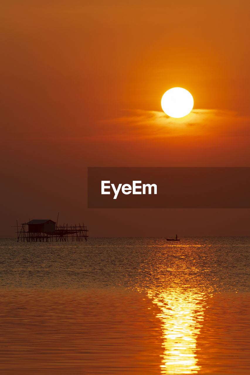 Scenic view of sea against orange sky