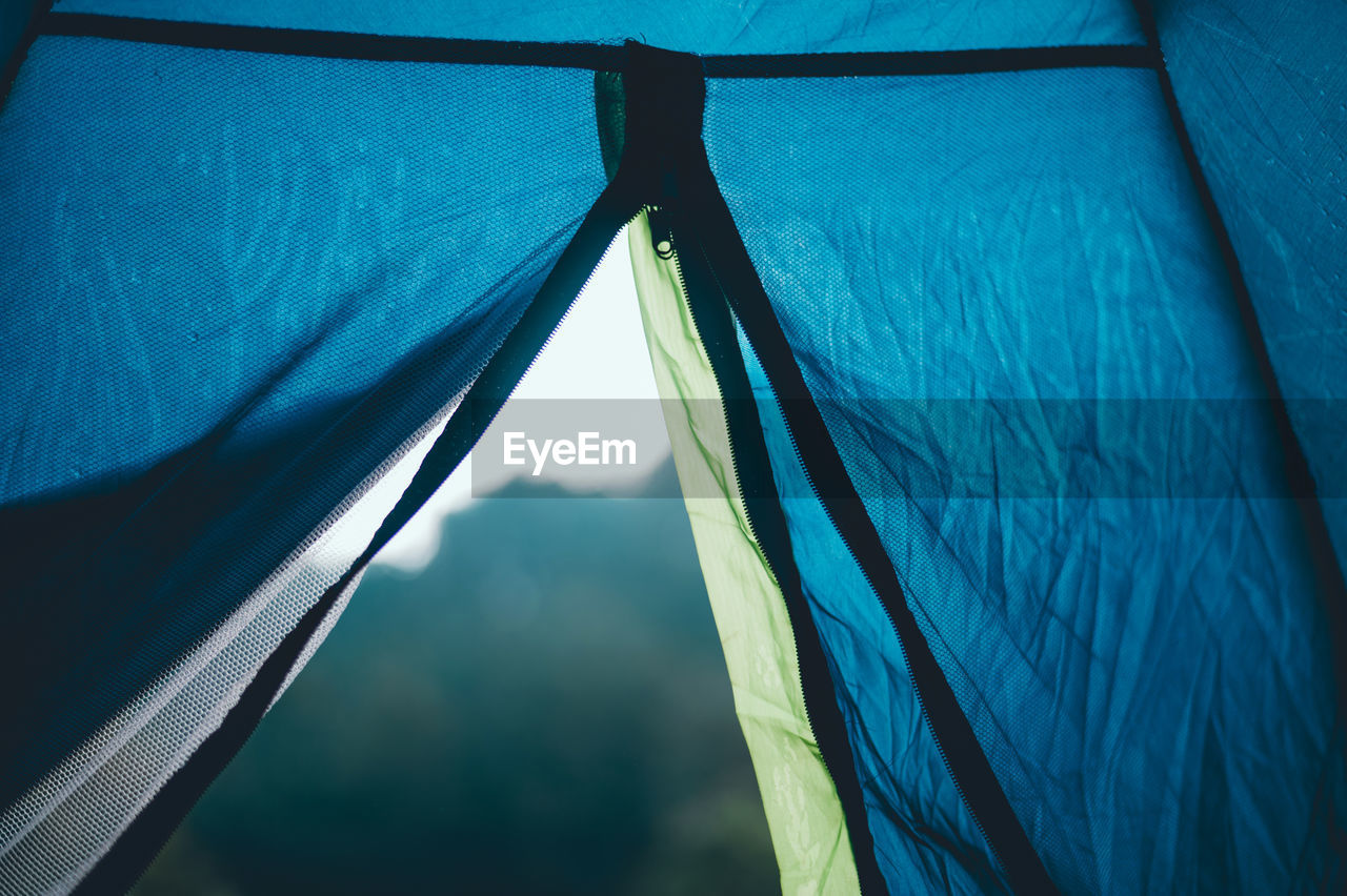 Low angle view of sky seen through open zipper of tent