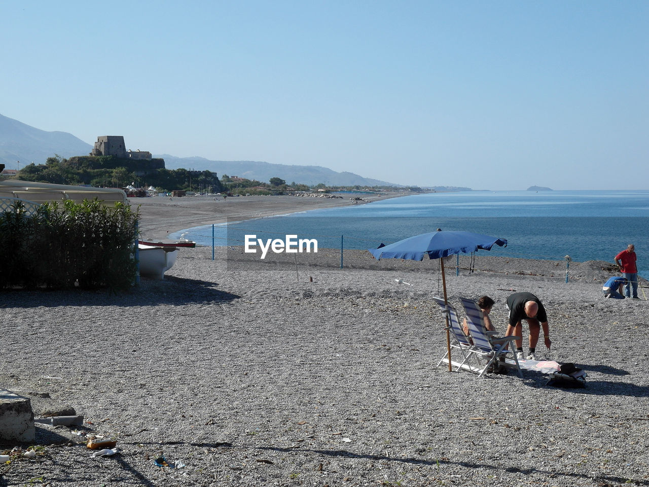 PEOPLE ON BEACH AGAINST CLEAR BLUE SKY