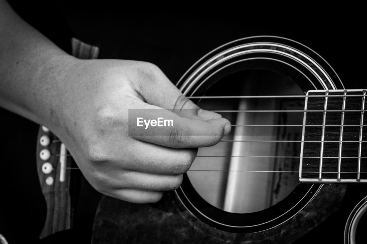 Close-up of man hand playing guitar