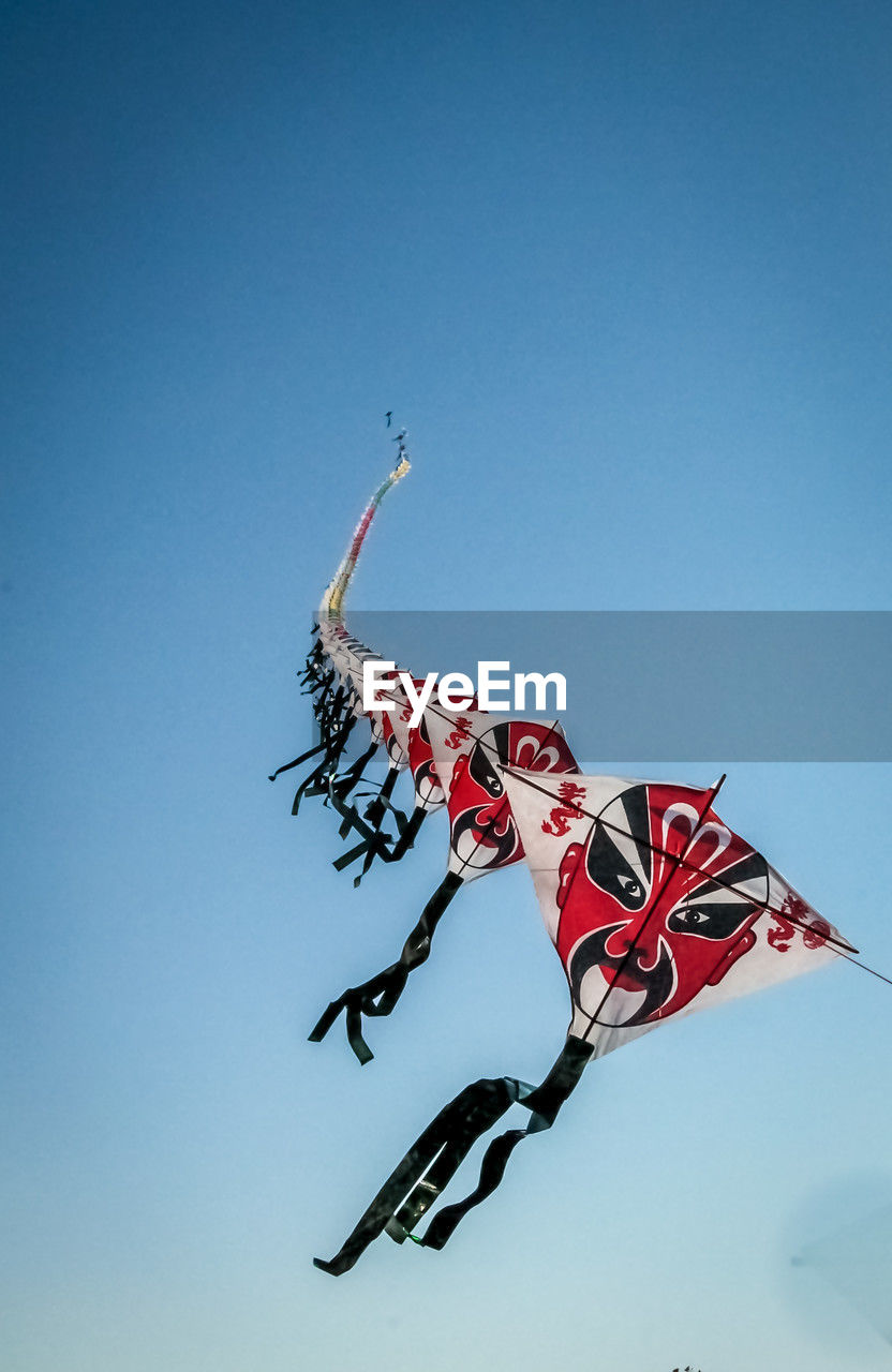sky, clear sky, nature, blue, windsports, flying, flag, toy, low angle view, sports, kite sports, extreme sports, copy space, patriotism, sunny, no people, motocross, day, outdoors, red, motion