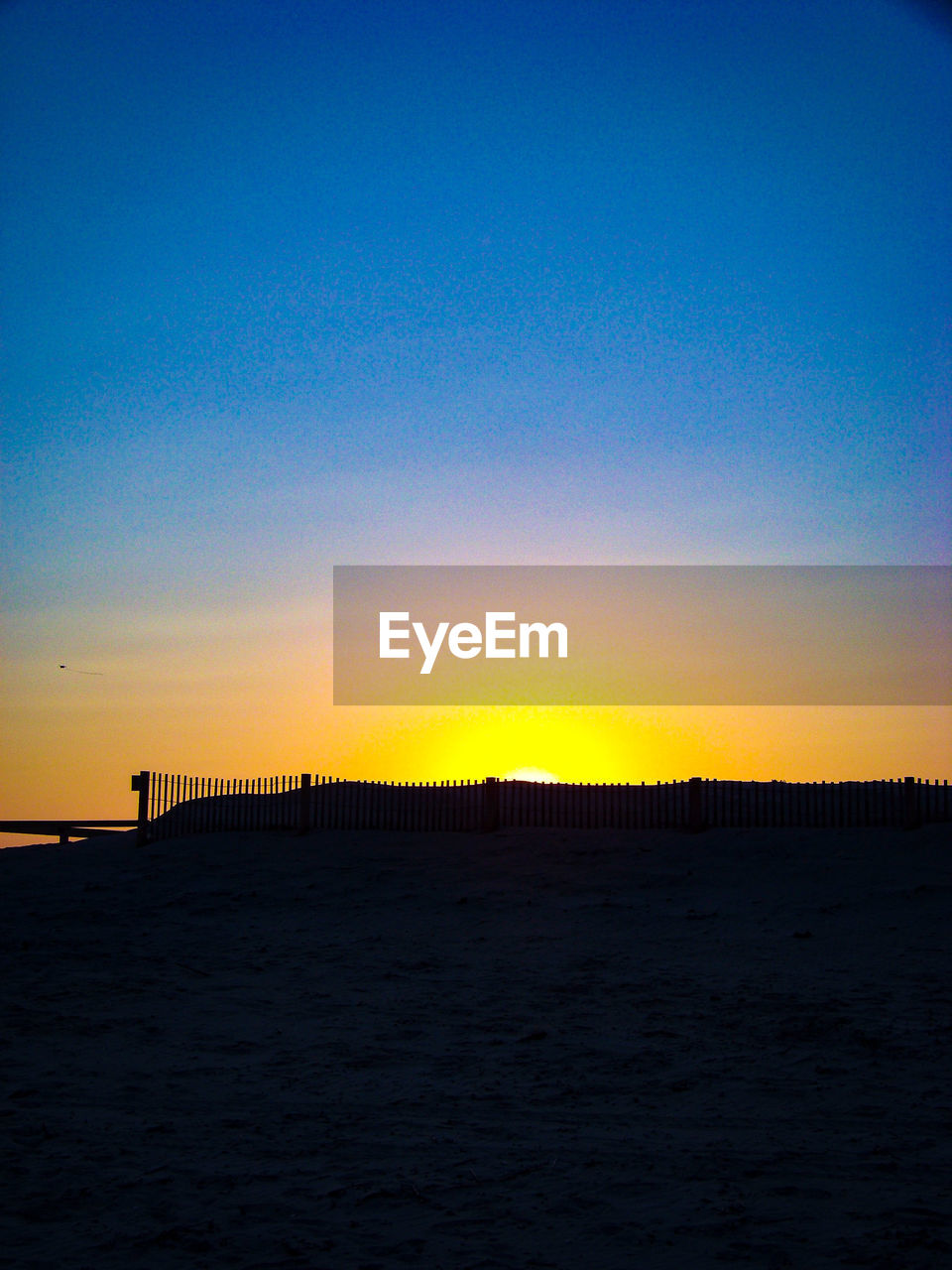 SCENIC VIEW OF BEACH AGAINST CLEAR SKY AT SUNSET