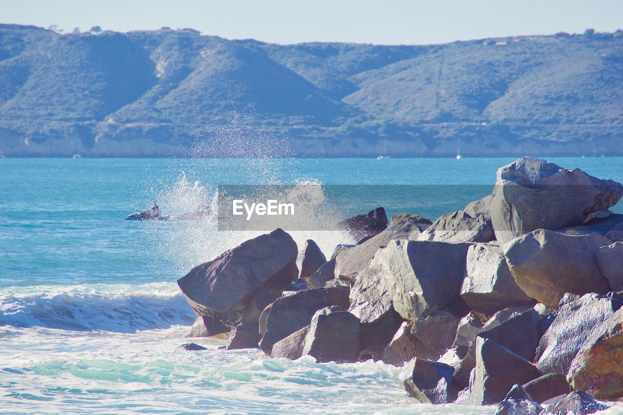 SCENIC VIEW OF SEA BY MOUNTAIN