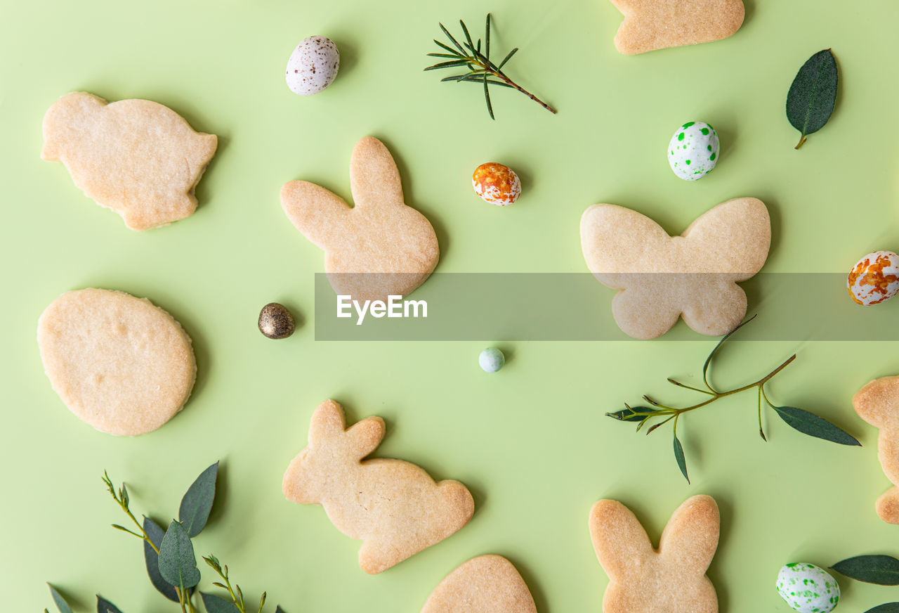 Easter cookies, candies shaped eggs, eucalyptus, flowers and quail eggs. happy easter concept