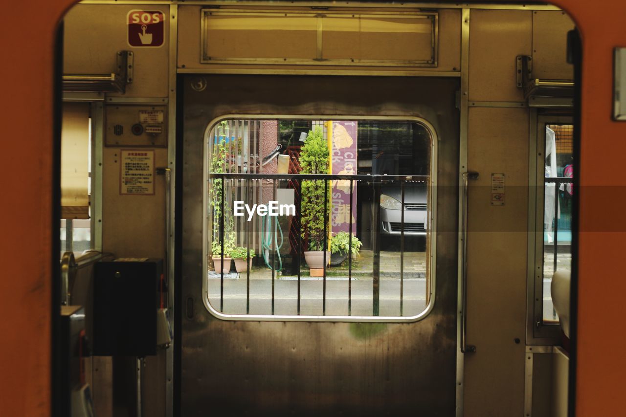 TRAIN SEEN THROUGH WINDOW OF DOOR