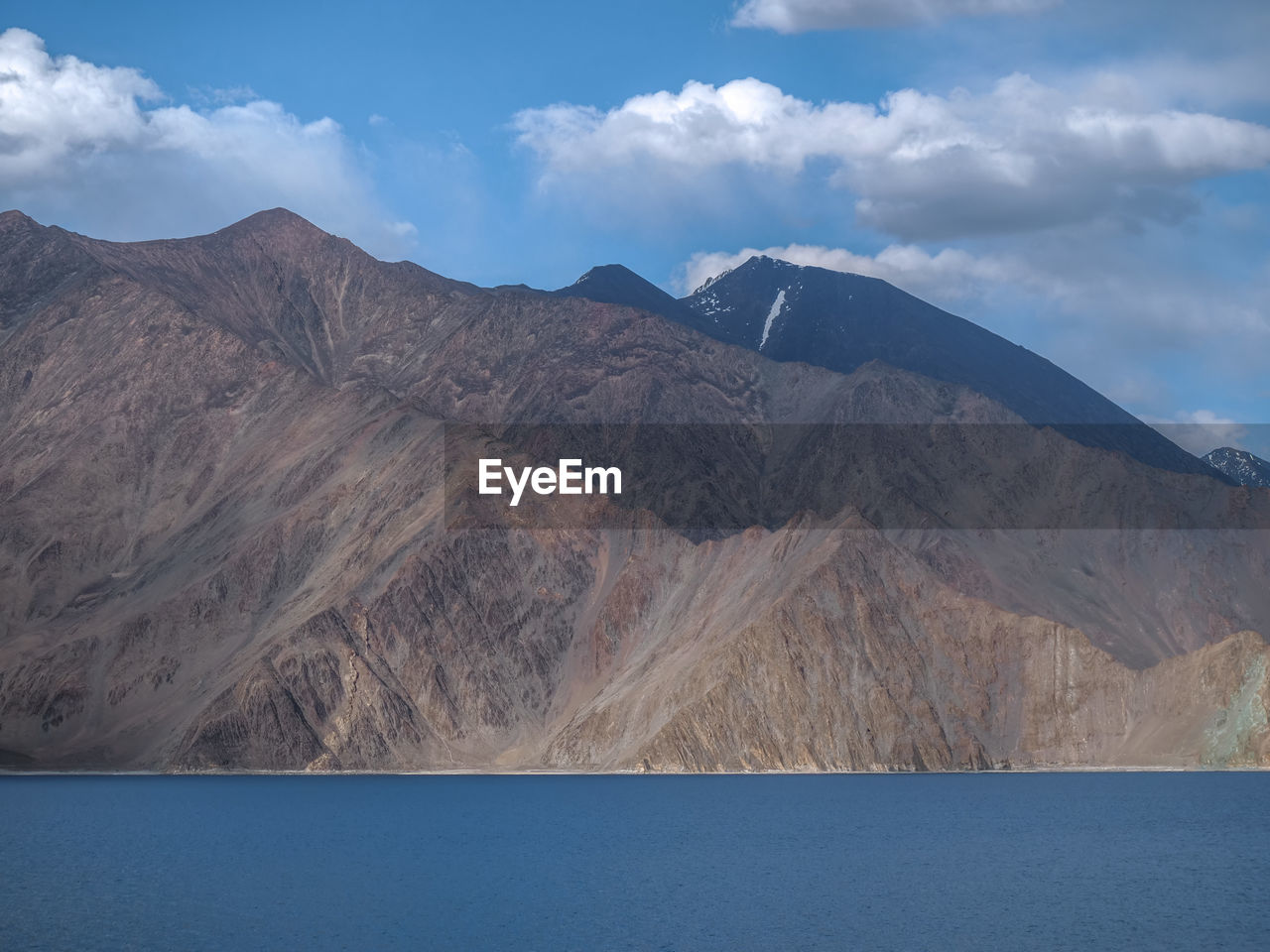 Scenic view of mountains against cloudy sky