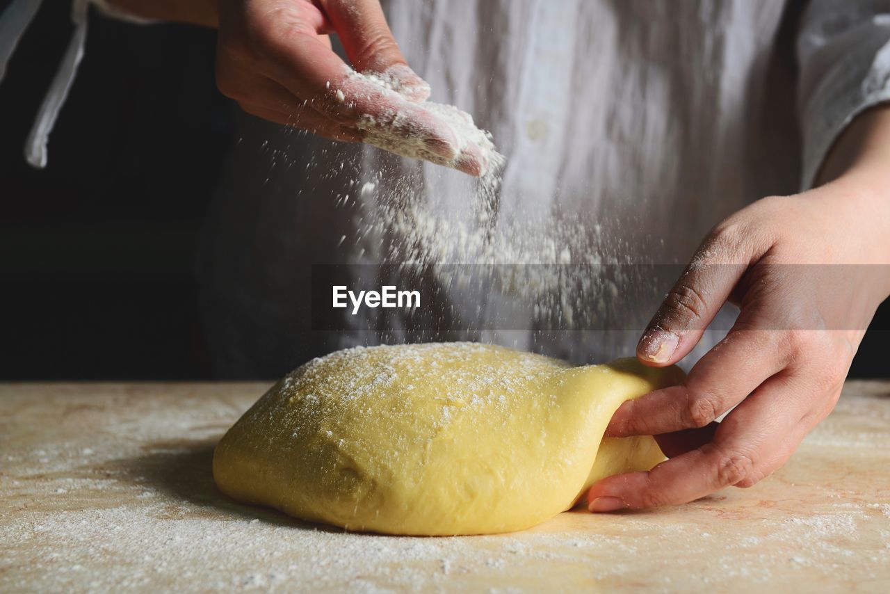 CROPPED IMAGE OF PERSON PREPARING FOOD ON TABLE