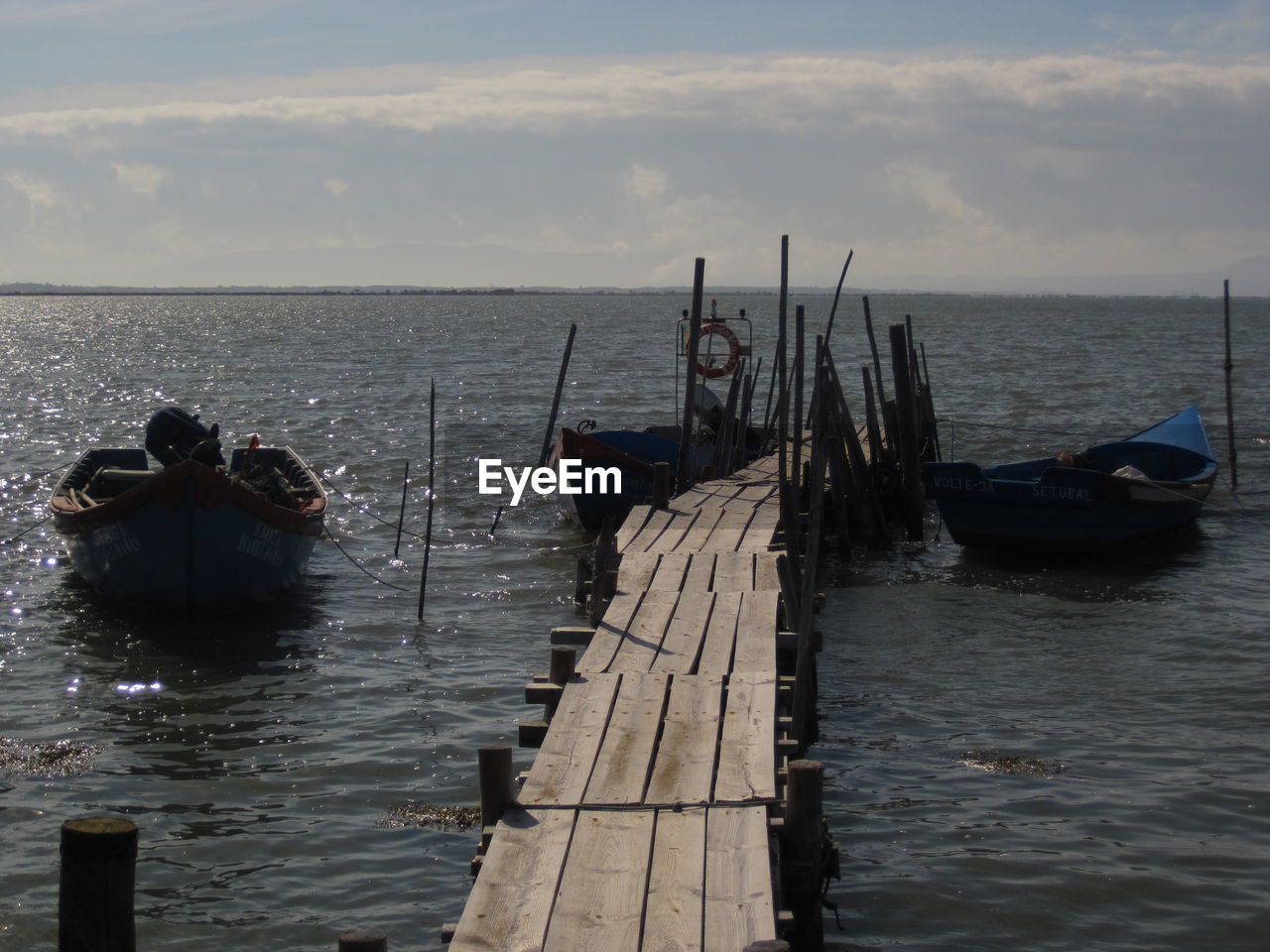 WOODEN POST IN SEA AGAINST SKY