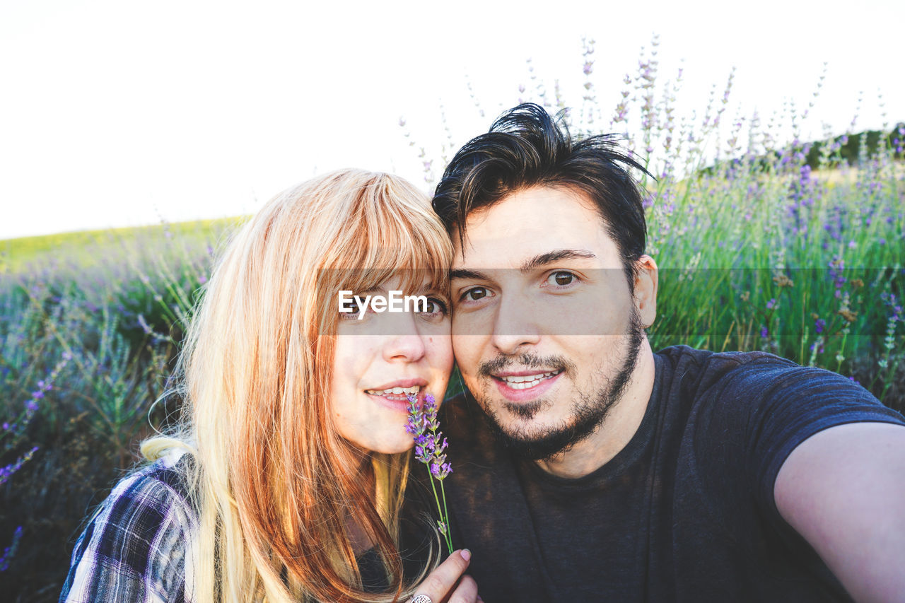 Portrait of smiling young couple on field